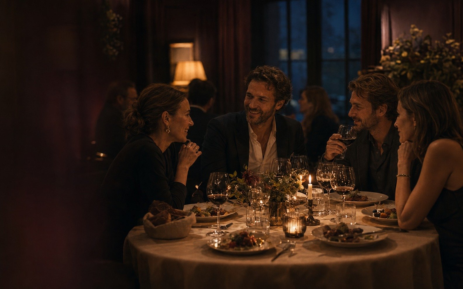Guests talking together at a warmly lit restaurant table